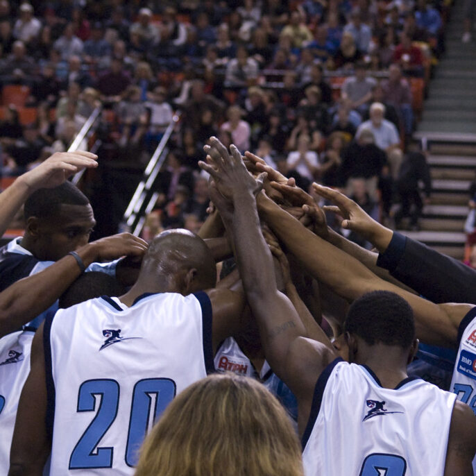 a basket ball team holds their hands up together