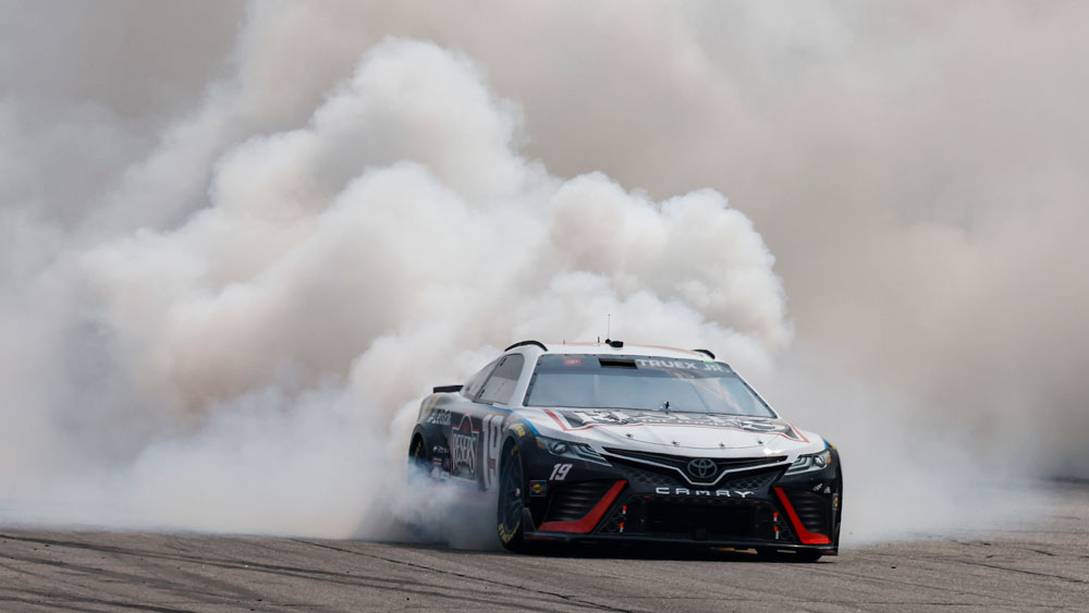 a race car with a plume of smoke